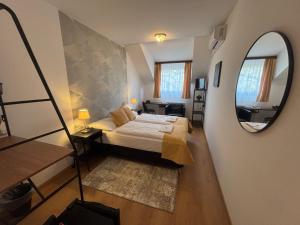 a small bedroom with a bed and a mirror at Hotel Gloria Budapest City Center in Budapest