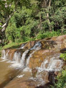 una cascata sul lato di un fiume di Chalés Cachoeira do Cafundó a Bueno Brandão