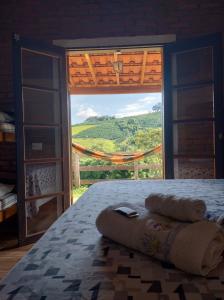 una camera con letto e vista su una finestra di Chalés Cachoeira do Cafundó a Bueno Brandão