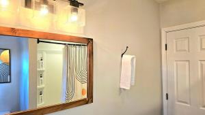 une salle de bain avec un miroir et une serviette dans l'établissement 2 King Bed Home, perfect for HPU, Furniture Market, à High Point 37 autres photos