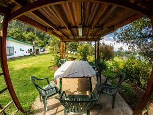 a table and chairs under a wooden pergola at La Juana Posada Campesina in Tenjo