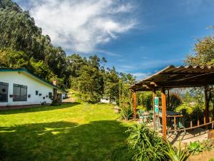 a yard with a house and a green lawn at La Juana Posada Campesina in Tenjo