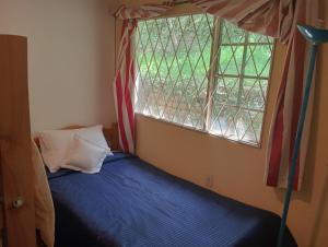 a bed in a room with a window at La Juana Posada Campesina in Tenjo