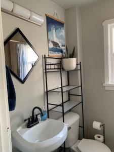 a bathroom with a sink and a toilet and a mirror at Burley Bungalow in Burley