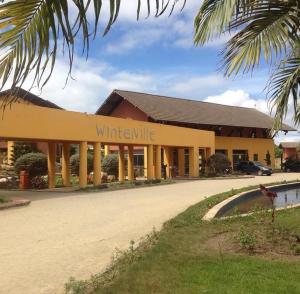 ein gelbes Gebäude mit einem weißen Messer-Schild darauf in der Unterkunft Flat no Winterville em Gravata in Gravatá