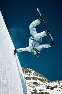 a person on a snowboard jumping off a snow covered slope at Grand Hotel des Bains Kempinski in St. Moritz +249 photos