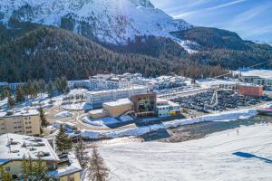 an aerial view of a resort with a snow covered mountain at Grand Hotel des Bains Kempinski in St. Moritz