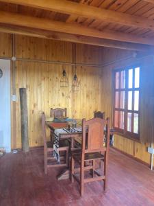 a wooden dining room with a table and chairs at Luna y Mar in Mar del Sur