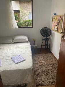 a bedroom with a bed and a window and a rug at Casa roxa in Itatiaia