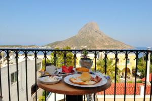 a table with breakfast food on a balcony with a mountain at Vouros Palace in Masouri
