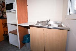 a small kitchen with a sink and a refrigerator at Hostel Metro in Warsaw
