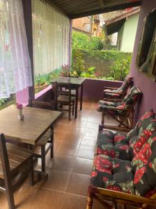 a living room with tables and chairs and a couch at Casa roxa in Itatiaia
