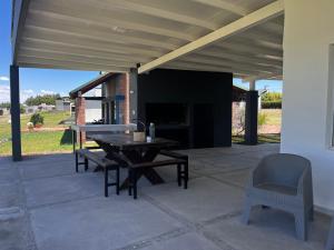 a patio with a wooden table and a chair at SIESTA al Lago in El Nihuil