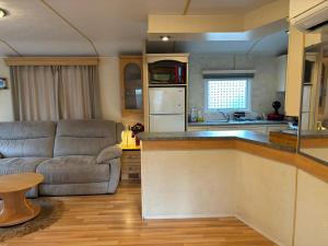 a kitchen and living room with a couch and a table at Saint tropez, Gassin , Mobil Home luxe chez Josy in Gassin