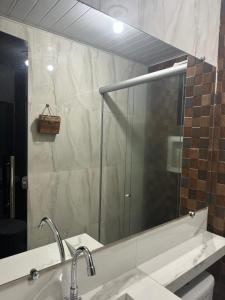 a bathroom with a sink and a large mirror at Condomínio Città maris in Marituba