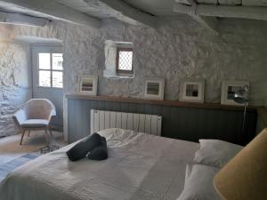 a bedroom with a bed and a chair and a window at La Maison Médiévale à colombage en Quercy in Puylagarde +24 photos