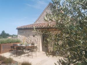 a patio with a table and chairs in front of a building at La Maison Médiévale à colombage en Quercy in Puylagarde