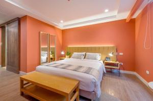 a bedroom with orange walls and a large bed at Luxury Escape by El Tesoro Perfect Location 302 in Medellín