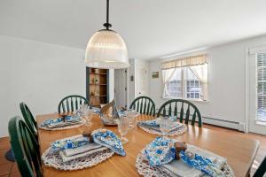 a dining room with a wooden table with chairs at Pool Half Mile to Beach in Harwich +32 photos