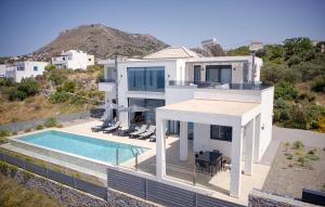a large white house with a swimming pool at Luxury Villa Apeiro in Plaka in Plaka