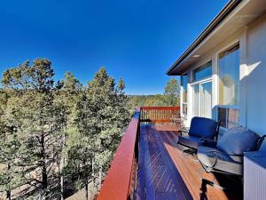 a balcony of a house with blue chairs on it at High Expectations in Ruidoso