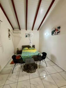 a room with a bed and chairs in it at Bungalow Tafial vue sur mer in Sainte-Anne +14 photos