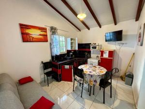 a living room with a table and a kitchen at Bungalow Tafial vue sur mer in Sainte-Anne