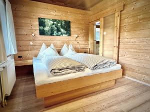a bedroom with a bed in a wooden room at Rafting Camp Palfau in Palfau