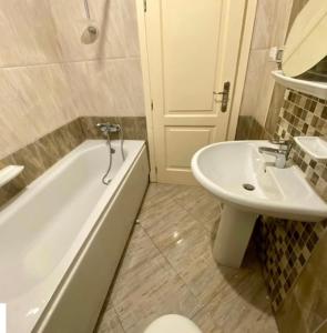 ein Badezimmer mit Waschbecken, Badewanne und Toilette in der Unterkunft Hotel in Madinaty