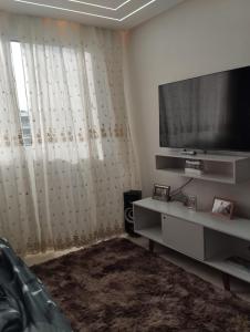 soggiorno con TV a schermo piatto e tende di Apartamento porto dos mares a Salvador