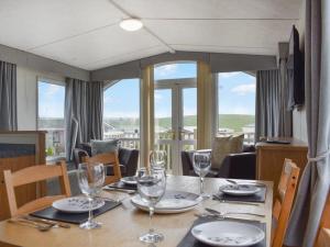 a dining room table with glasses and plates on it at Skiddaw Lodges- The Lake District in Plumbland