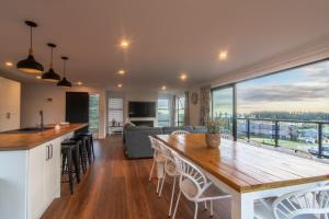 a kitchen and living room with a large wooden table at Stunning Views, Contemporary, Escape - KK24113 in Kaikoura