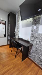 a black desk in a room with a stone wall at Colisseum Roma - Vive Claro -El cubo movistar campin in Bogotá