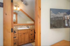 een badkamer met een wastafel en een spiegel bij Luxe Winter Park Escape - 5BR with Hot Tub & Game Room in Winter Park +42 foto's