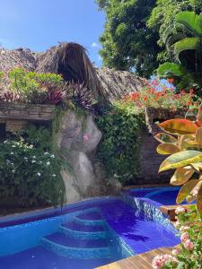 una piscina con escaleras en un jardín en Hostal Antawara Tayrona, en El Zaino