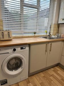 a kitchen with a washing machine and a sink at Cosy & Stylish 2 Bed Ground Floor Flat in Dartford in Dartford