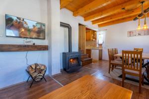 a living room with a stove and a dining room at Vikend Kuća Mirko in Risovac