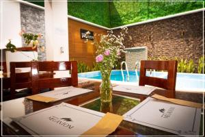 a table with a vase of flowers on top of it at Grand Hotel Megantoni in Quillabamba