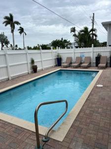 a swimming pool with chairs and a white fence at Island Pearl by Sun Palace Vacations in Fort Myers Beach