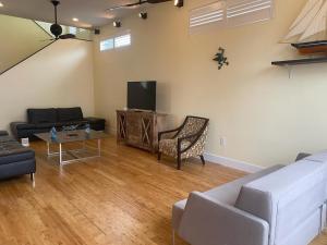 a living room with a couch and a tv at Island Pearl by Sun Palace Vacations in Fort Myers Beach