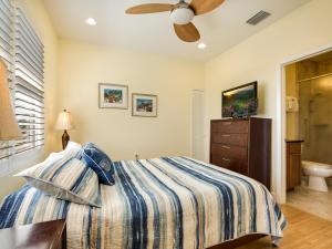 a bedroom with a bed and a ceiling fan at Island Pearl by Sun Palace Vacations in Fort Myers Beach +28 photos