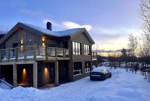 una casa con un coche aparcado en la nieve en Immaculate Cabin in the Heart of Beitostølen, en Beitostølen