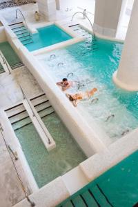 a group of people swimming in a swimming pool at Royal Hideaway Sancti Petri in Chiclana de la Frontera