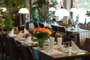 a restaurant with tables and chairs with flowers on them at Hotel Höllsteiner Hof in Steinen