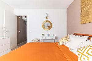 a bedroom with an orange bed and a mirror at Nel Borgo Antico in Riomaggiore