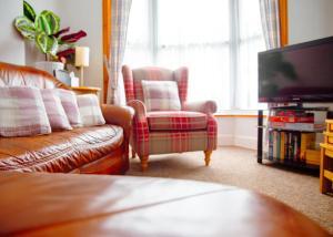 a living room with a couch and a television at Purple Cloud Cosy 4 bed Cottage with Garden Parking Pet-Friendly in Portsmouth