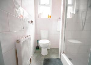 a white bathroom with a toilet and a shower at Purple Cloud Cosy 4 bed Cottage with Garden Parking Pet-Friendly in Portsmouth