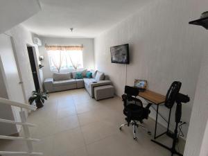 ein Wohnzimmer mit einer Couch und einem Tisch und Stühlen in der Unterkunft Casa Holkan, Playa del Carmen in Playa del Carmen