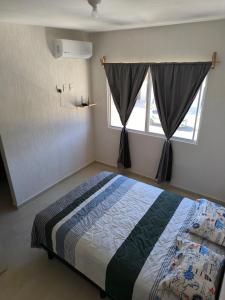 ein Schlafzimmer mit einem Bett und einem Fenster in der Unterkunft Casa Holkan, Playa del Carmen in Playa del Carmen