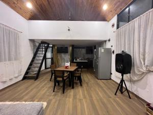 a kitchen and dining room with a table and a refrigerator at Cabaña ACALU in Villeta +6 photos